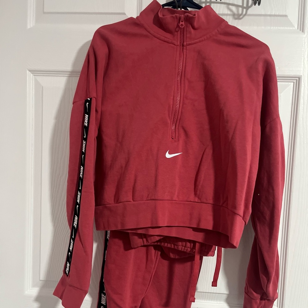 Nike suit salmon pink color with Nike logo down sides  size L